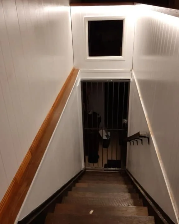 LED strip lighting under a new timber handrail down a white stairwell
